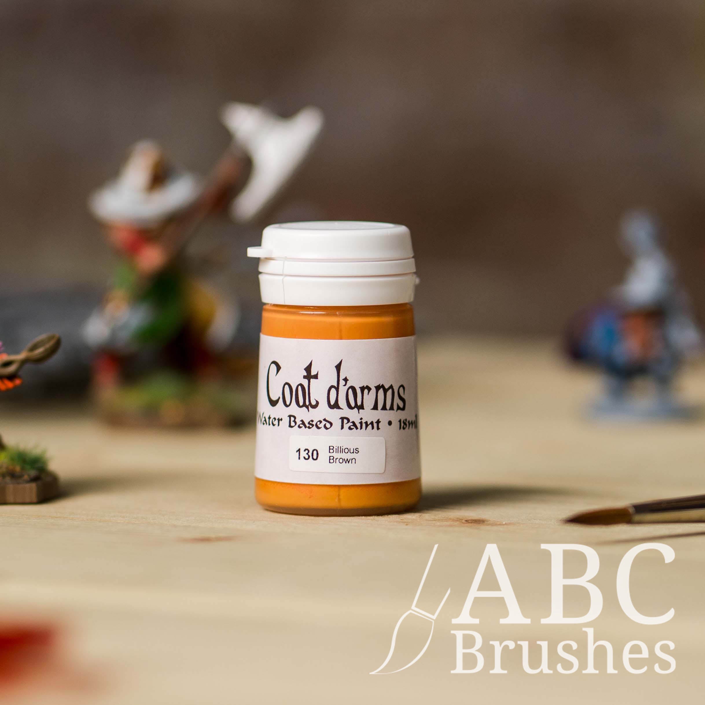 Bottle of Coat d'Arms acrylic paint in the colour Billious Brown, with various wargaming models and an abc paintbrush in the background, on a wooden surface.