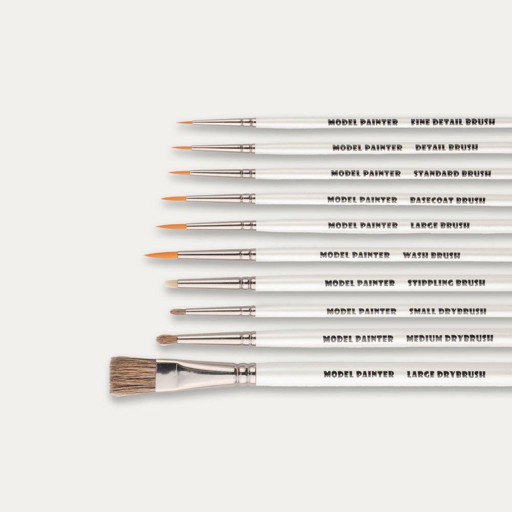 Closeup of the tips of ABC Brushes Model Painter Synthetic and Dry Brushes set laid out sideways on a white background.