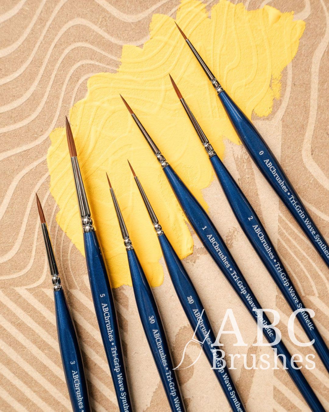 Set of ABC Brushes Tri-Grip Wave Synthetic brushes on a ABC drybrush board with yellow paint covering part of it. 