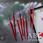 ABC Brushes Tri-Grip Detailer range on a paint covered cutting mat and next to a wet palette.