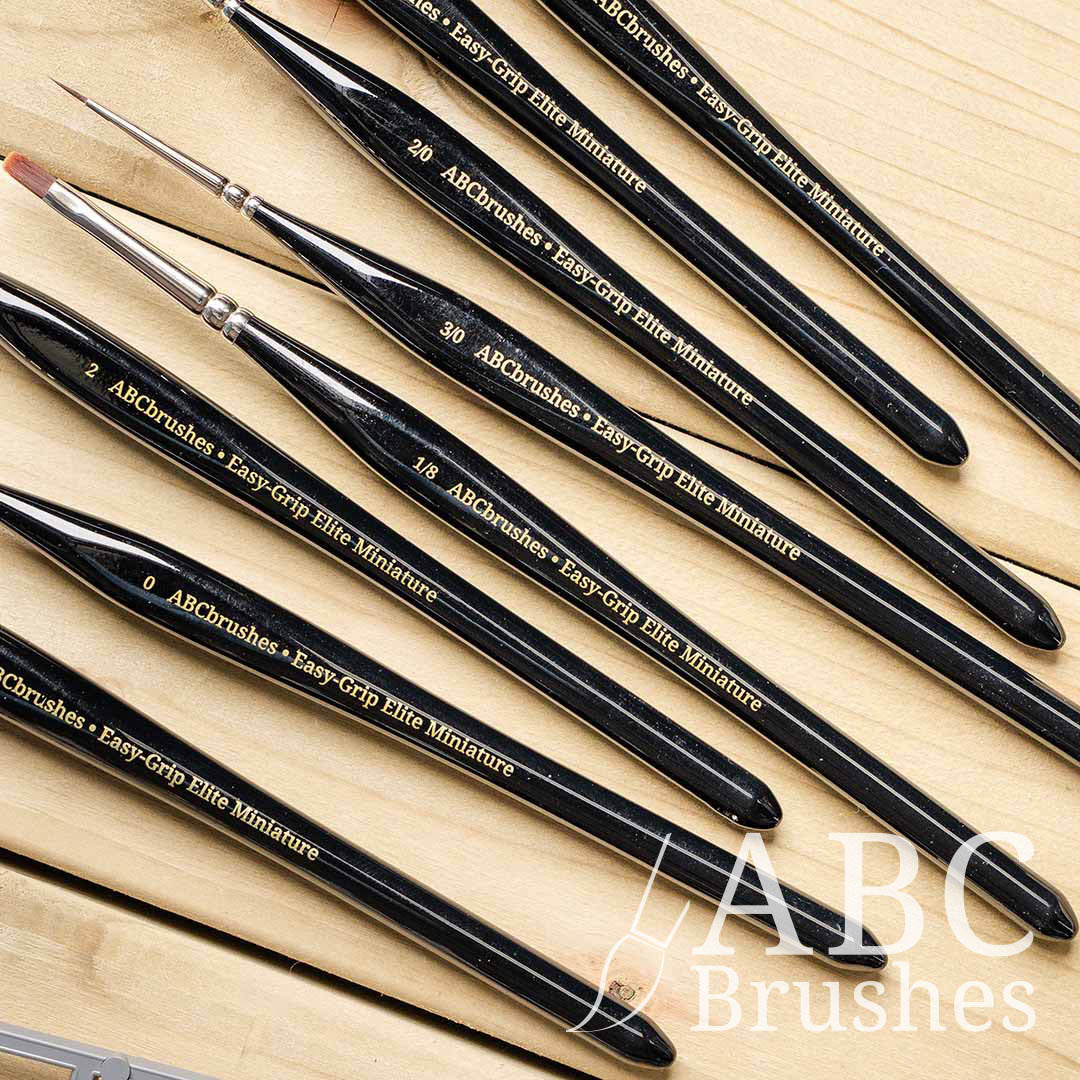 Close-up of the handles on the ABC Brushes Easy-Grip Elite Miniature Brush range on a wooden background.