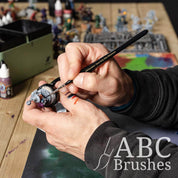 Painting a base coat on a wizard mini with an Painting a monkey astronaut mini figure with an ABC Brushes Easy-Grip Elite Miniature Brush. 