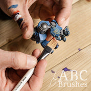 Using a Pro Arte Comb Paint Brush to apply rust weathering to a blue robot mini figure. 