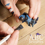 Using a Pro Arte Comb Paint Brush to apply rust weathering to a blue robot mini figure. 