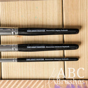 Closeup of the handles of the Army Painter Masterclass Drybrush set on a wooden background. 