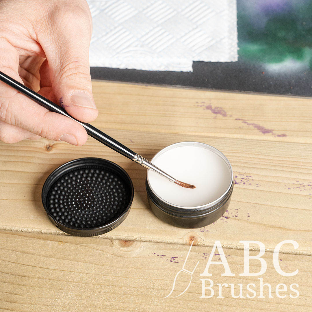 Someone cleaning a paintbrush with ABC Brushes brush cleaner.