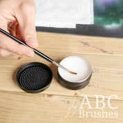 Someone cleaning a paintbrush with ABC Brushes brush cleaner.