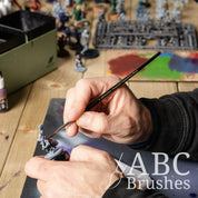 Painting a purple basecoat onto a mini with an ABC Brushes Vanguard paint brush.