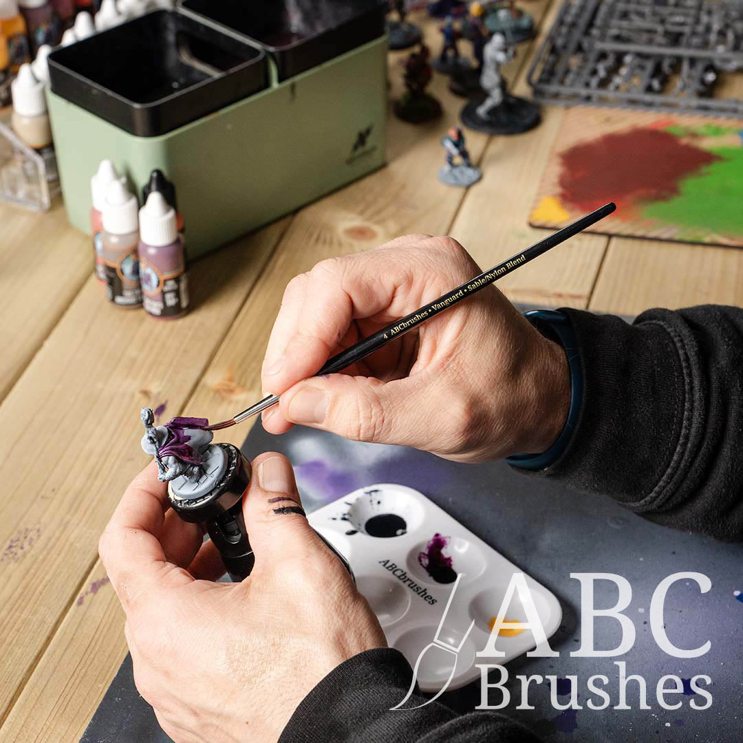 Painting a purple basecoat onto a mini with an ABC Brushes Vanguard paint brush.