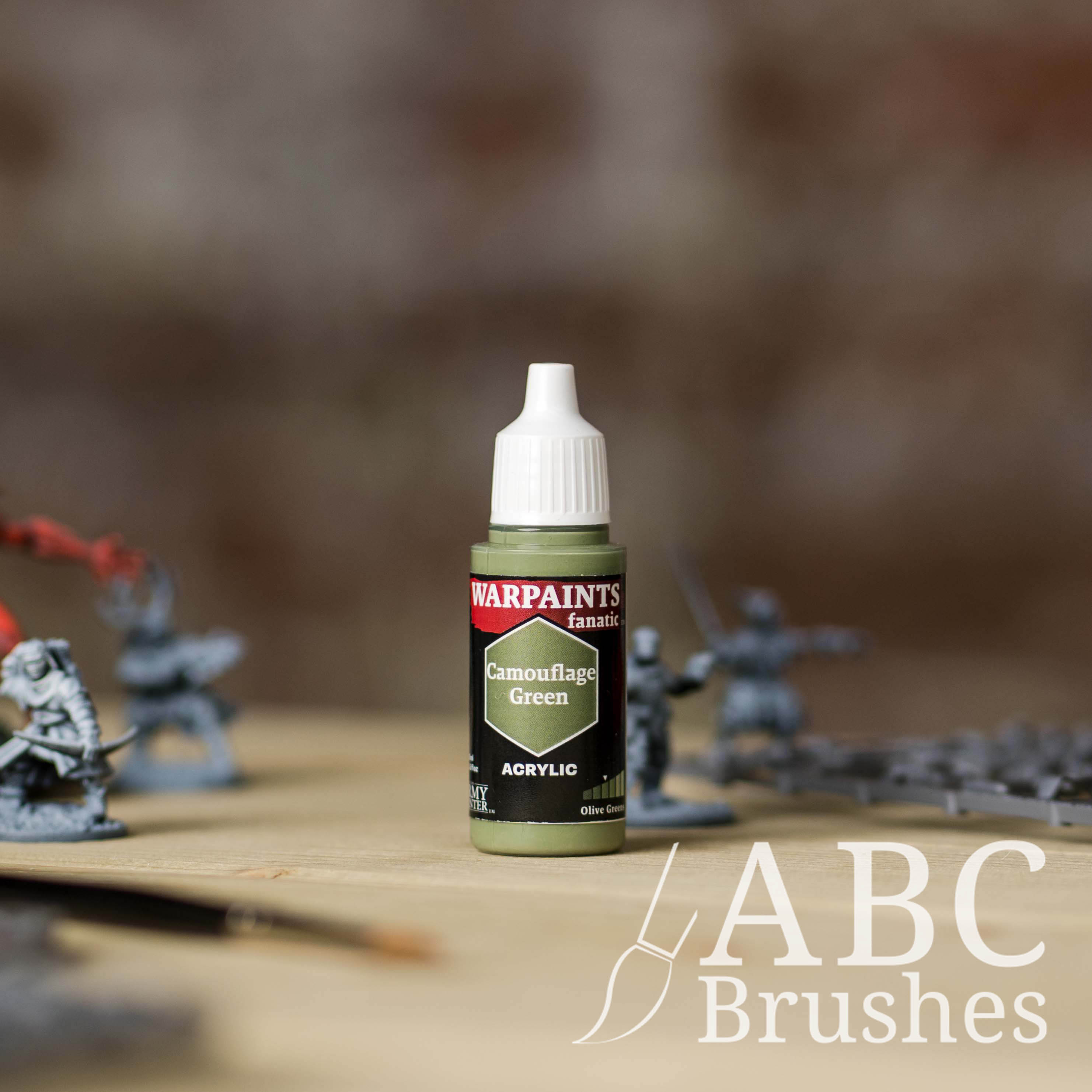 Bottle of the Army Painter Fanatics in the colour Camouflage Green on a white background. There are splatters of paint emerging from the bottom of the paint bottle. 