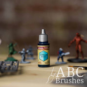 Bottle of the Army Painters Speedpaint in the colour Caribbean Ocean, with wargaming models and an ABC paintbrush in the background, on a wooden surface.