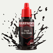 Bottle of the Army Painter Fanatics Wash in the colour Dark Skin Shade on a white background. There are splatters of paint emerging from the bottom of the paint bottle. 