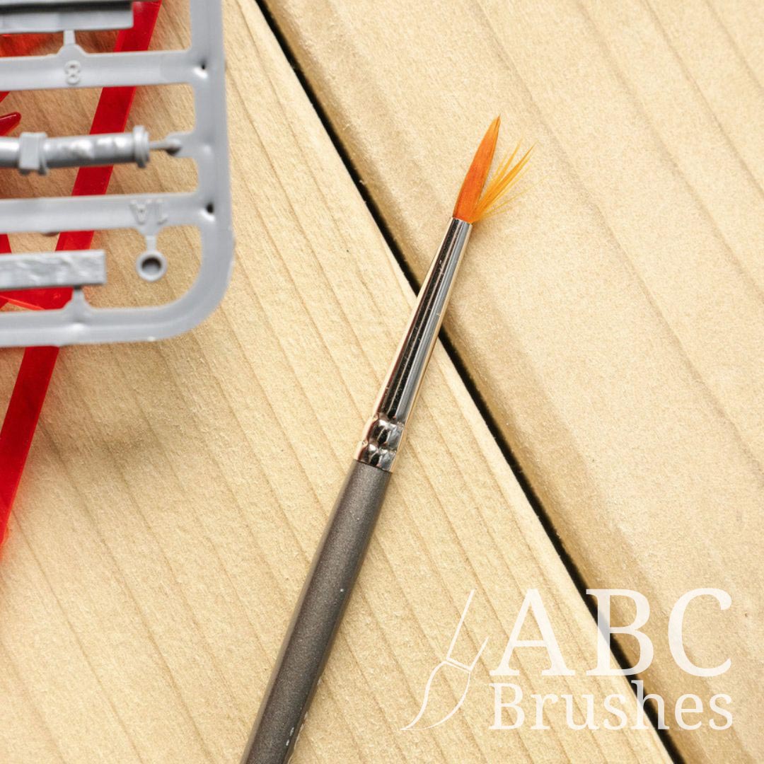 A ABC Prolon paintbrush with splayed bristles on a wooden background. 