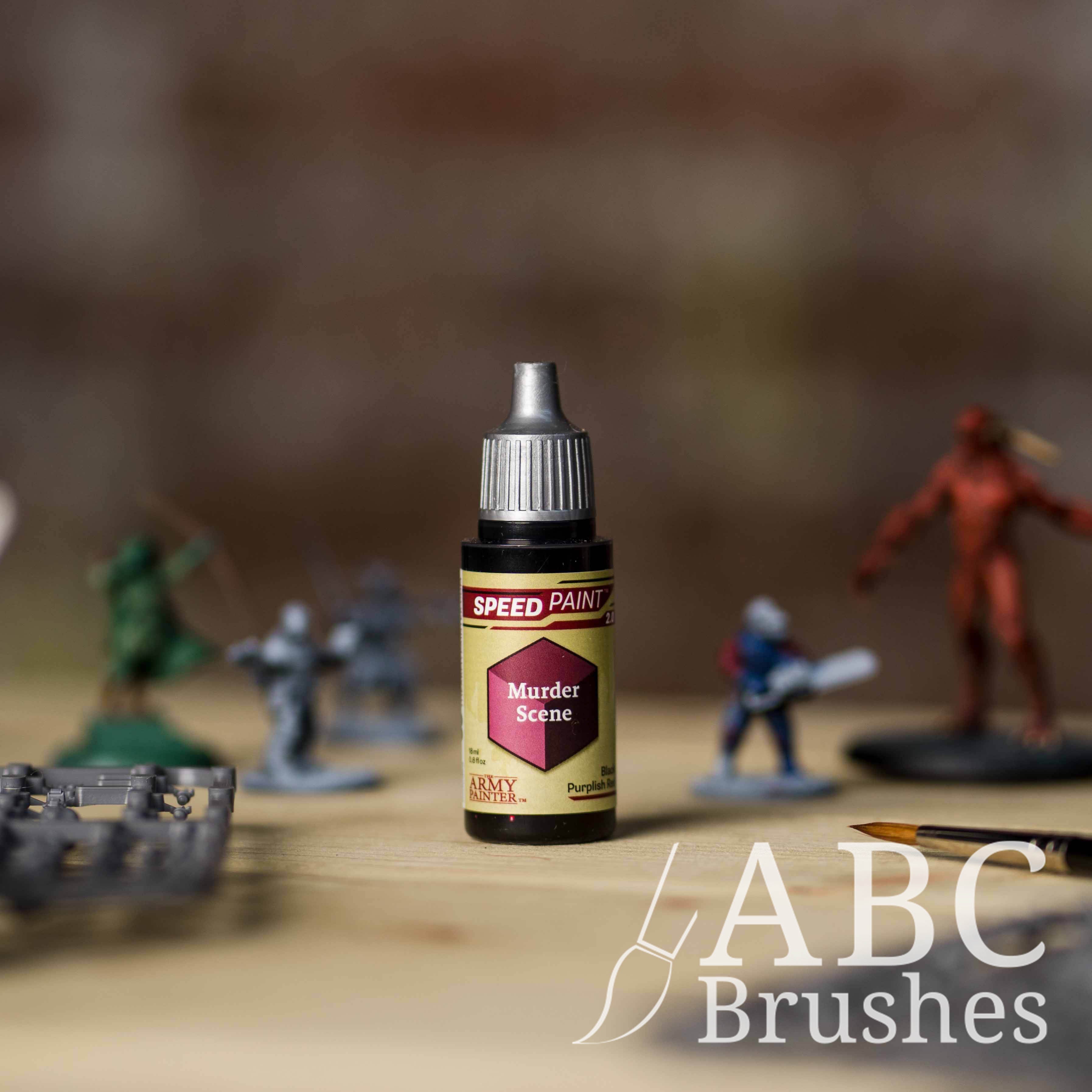 Bottle of the Army Painters Speedpaint in the colour Murder Scene, with wargaming models and an ABC paintbrush in the background, on a wooden surface.