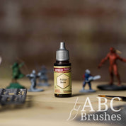 Bottle of the Army Painters Speedpaint in the colour Pallid Bone, with wargaming models and an ABC paintbrush in the background, on a wooden surface.