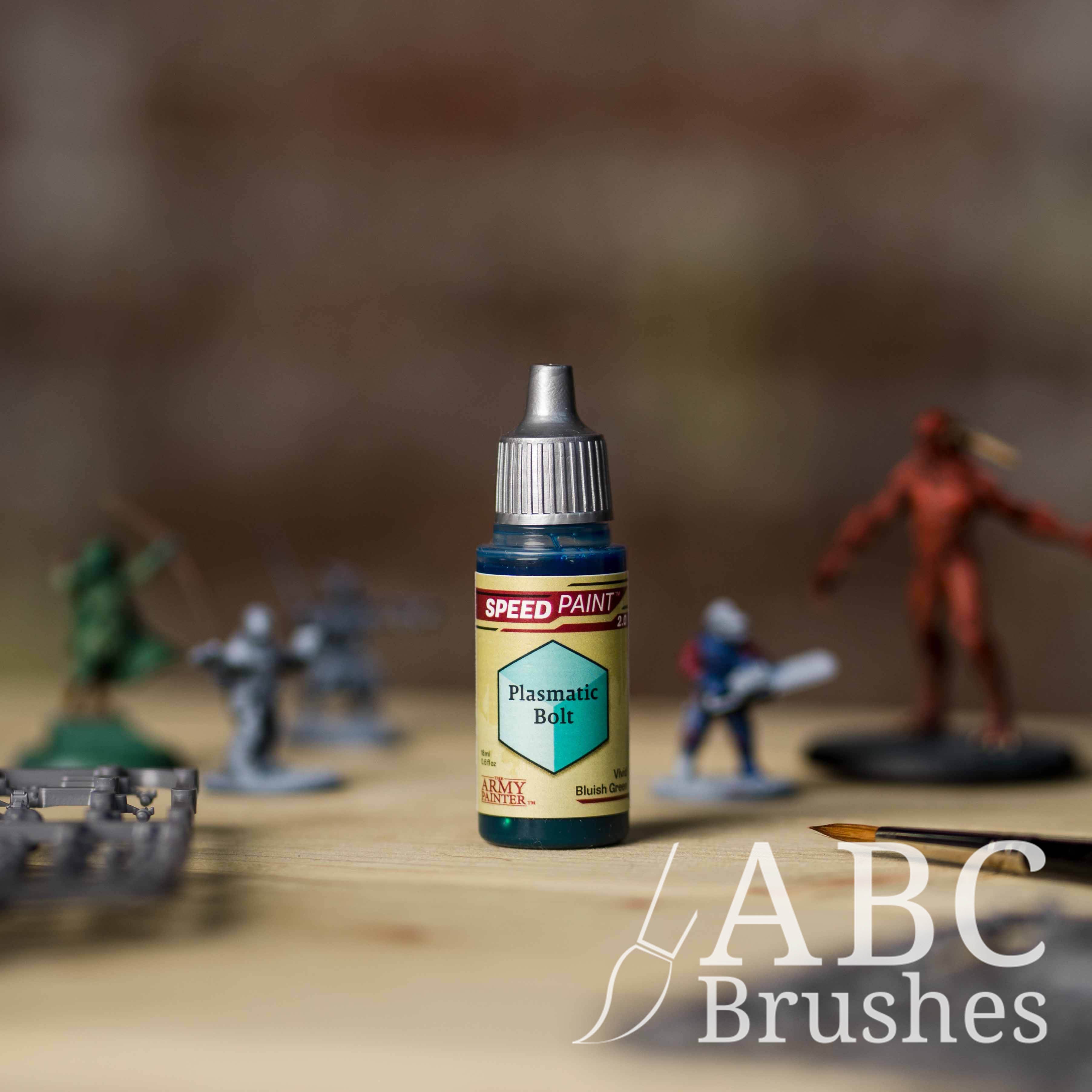 Bottle of the Army Painters Speedpaint in the colour Palsmatic Bolt, with wargaming models and an ABC paintbrush in the background, on a wooden surface.