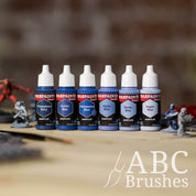 Army Painter Fanatics Strong Pale Blues Triad on a wooden surface. There are wargaming models and an ABC paint brush next to them.
