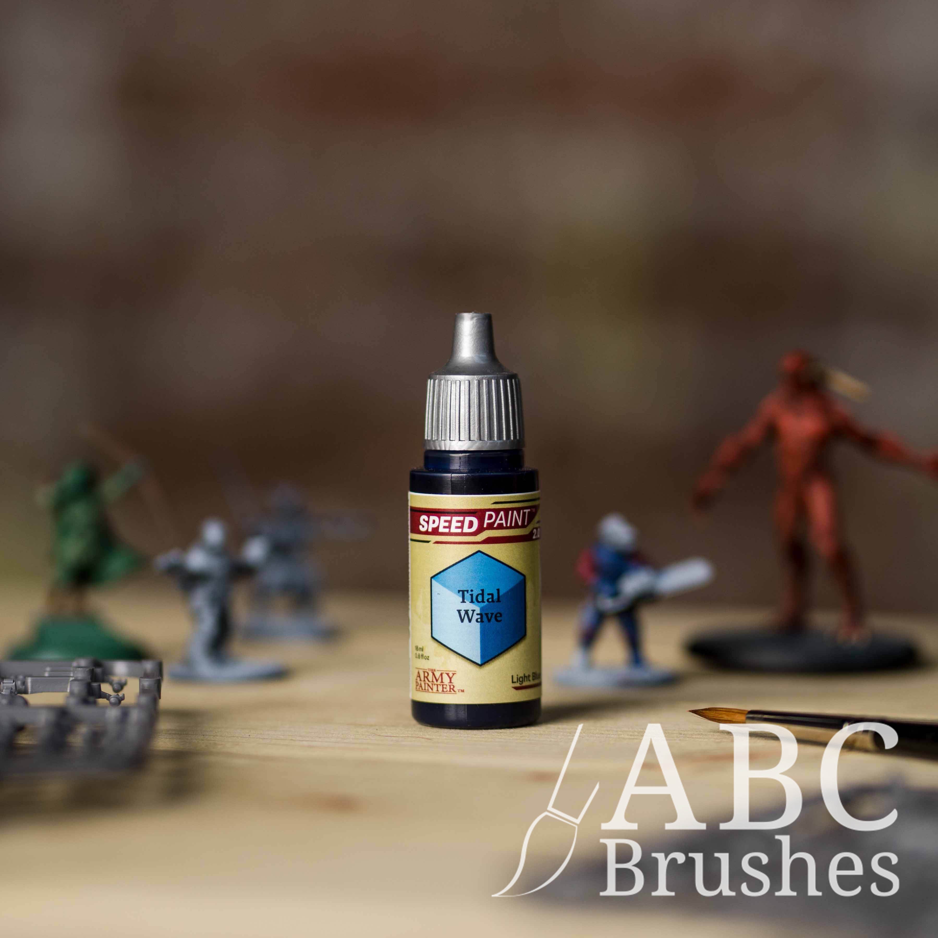 Bottle of the Army Painters Speedpaint in the colour Tidal Wave, with wargaming models and an ABC paintbrush in the background, on a wooden surface.