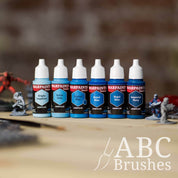 Army Painter Fanatics Vivid Blues Triad on a wooden surface. There are wargaming models and an ABC paint brush next to them.