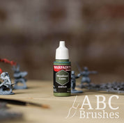 Bottle of the Army Painter Fanatics in the colour Woodland Camo on a white background. There are splatters of paint emerging from the bottom of the paint bottle. 