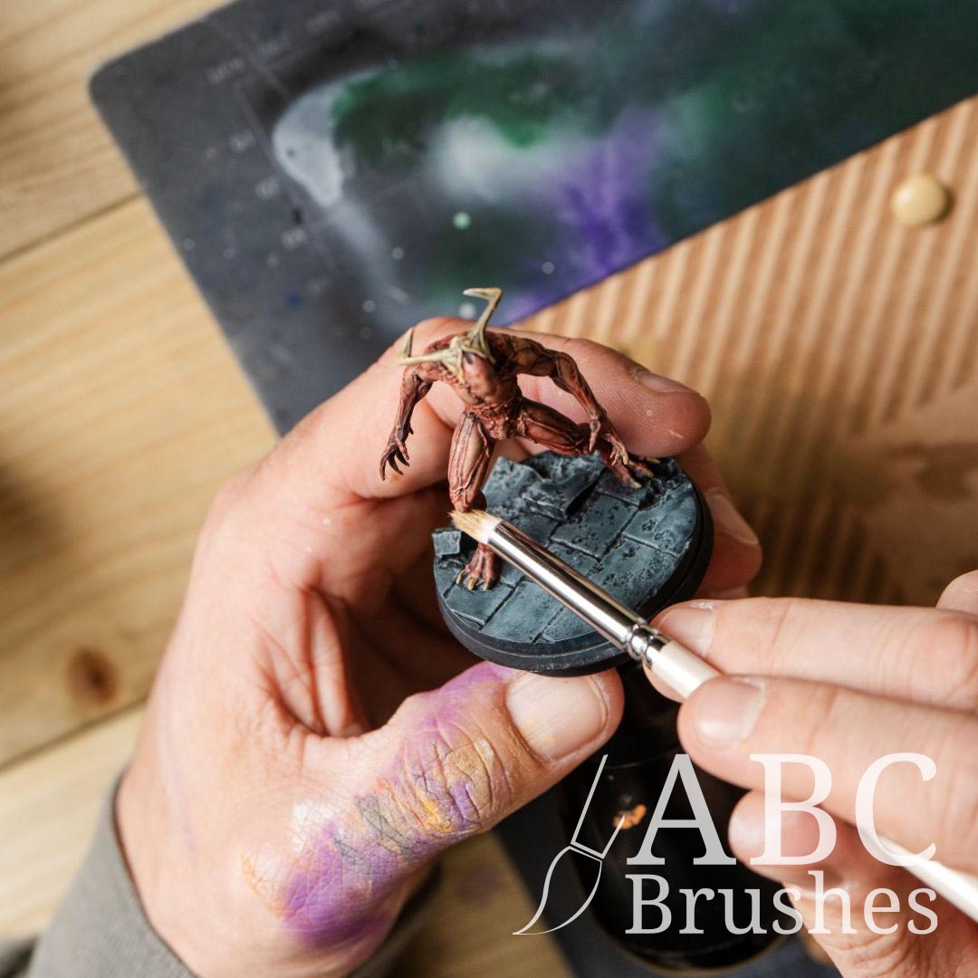 Applying brown dry brushing to a red demon mini figure with a Pro Arte Dry brush. 