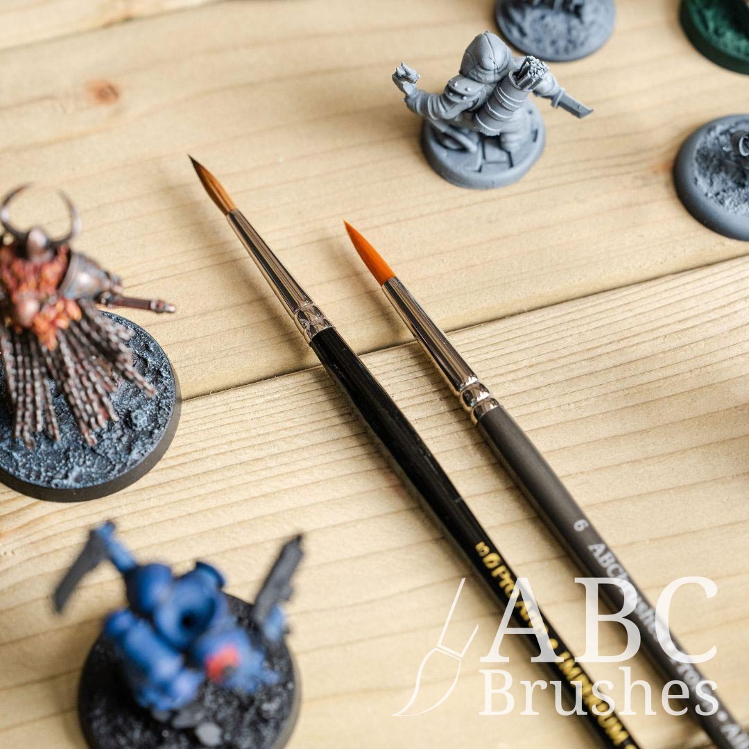 Pro Arte Prolon and Imperium paintbrushes, surrounded by a range of mini figures.